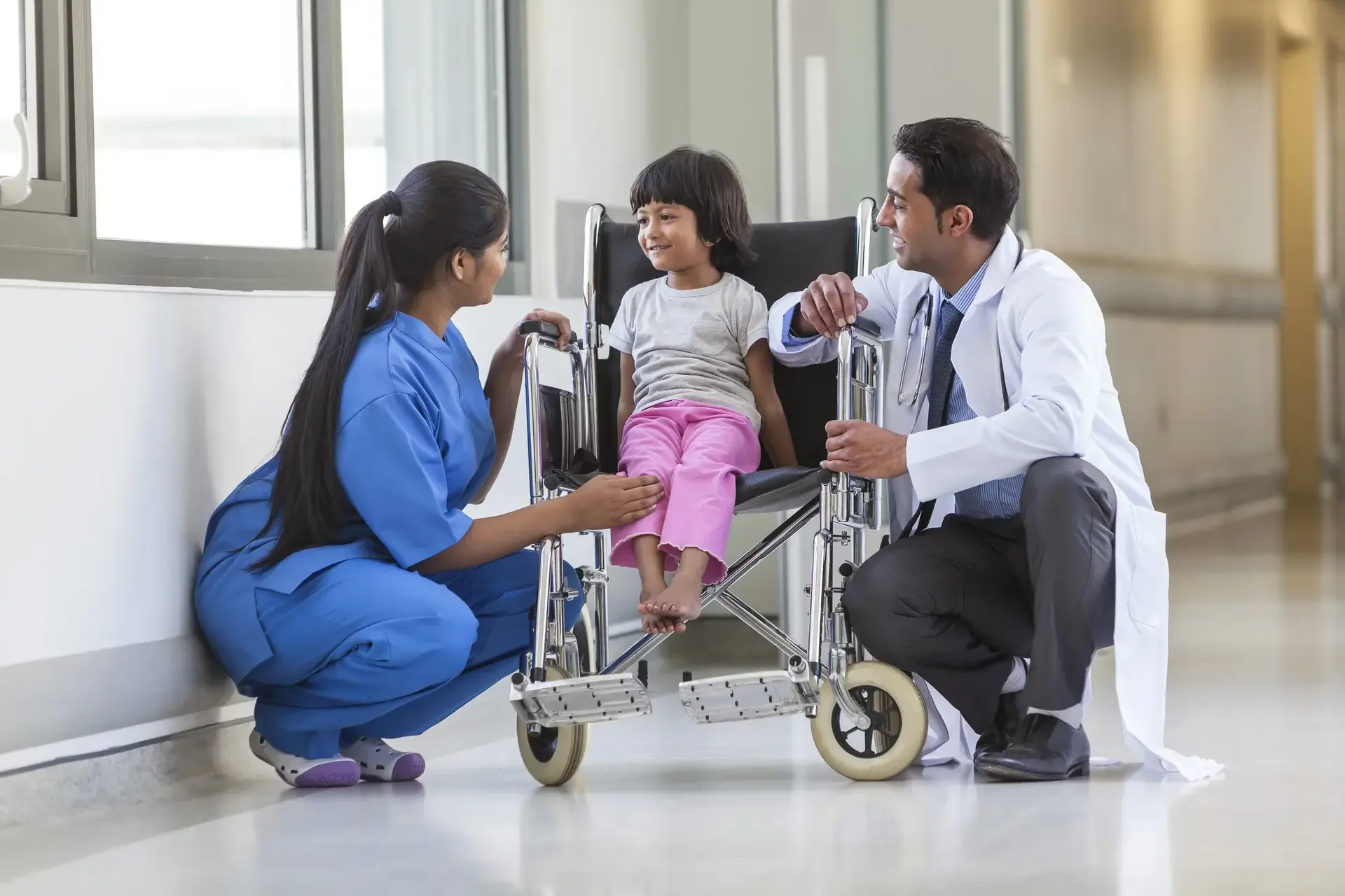 Nurse and doctor talking with a girl in a wheelchair