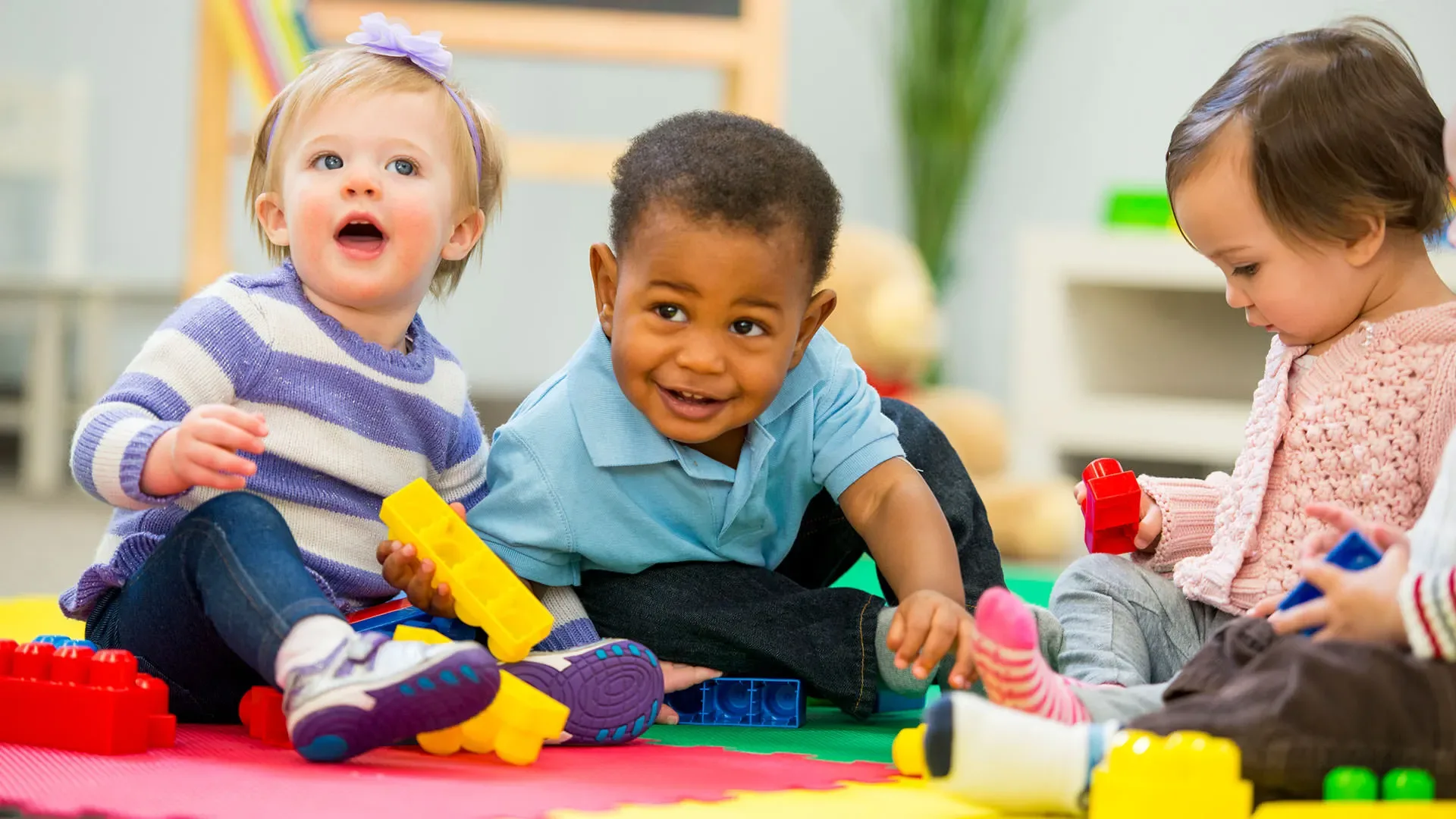 Toddlers playing together with colorful blocks