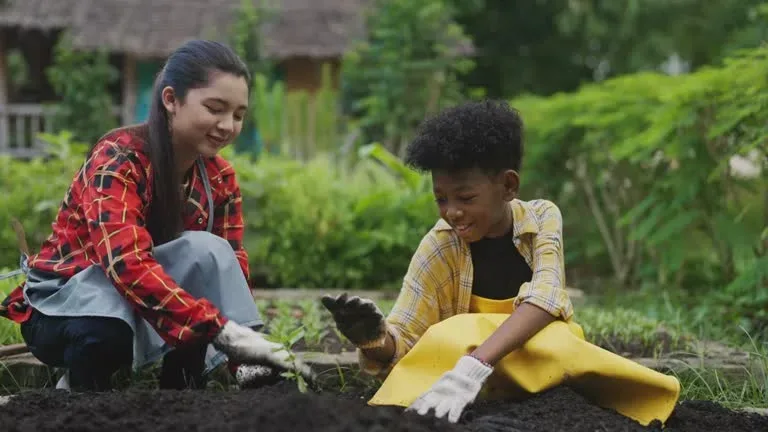 Caregiver gardening outdoors with a child