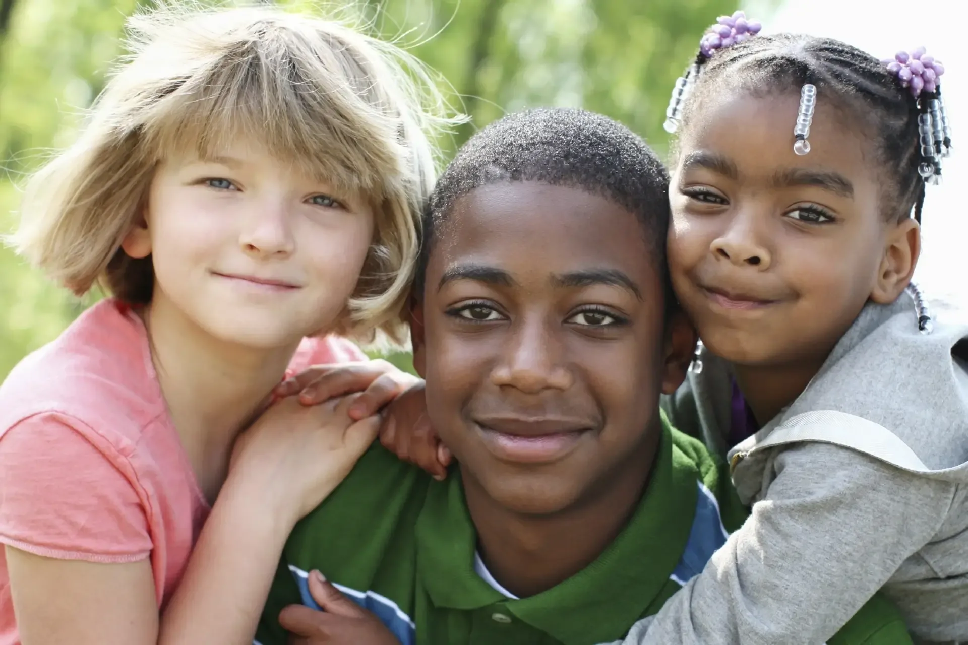 Three smiling children leaning together