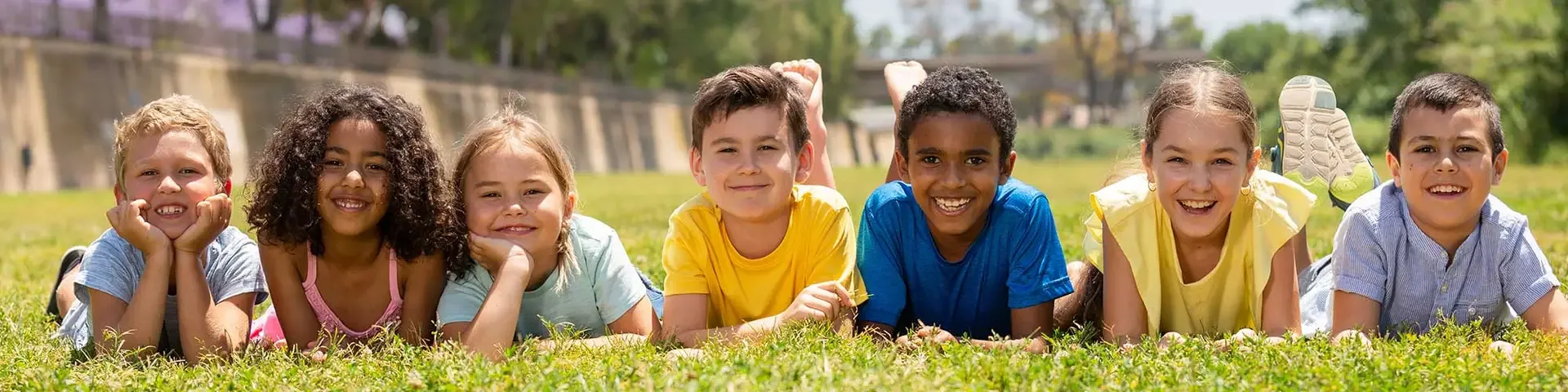 Group of smiling children lying on the grass