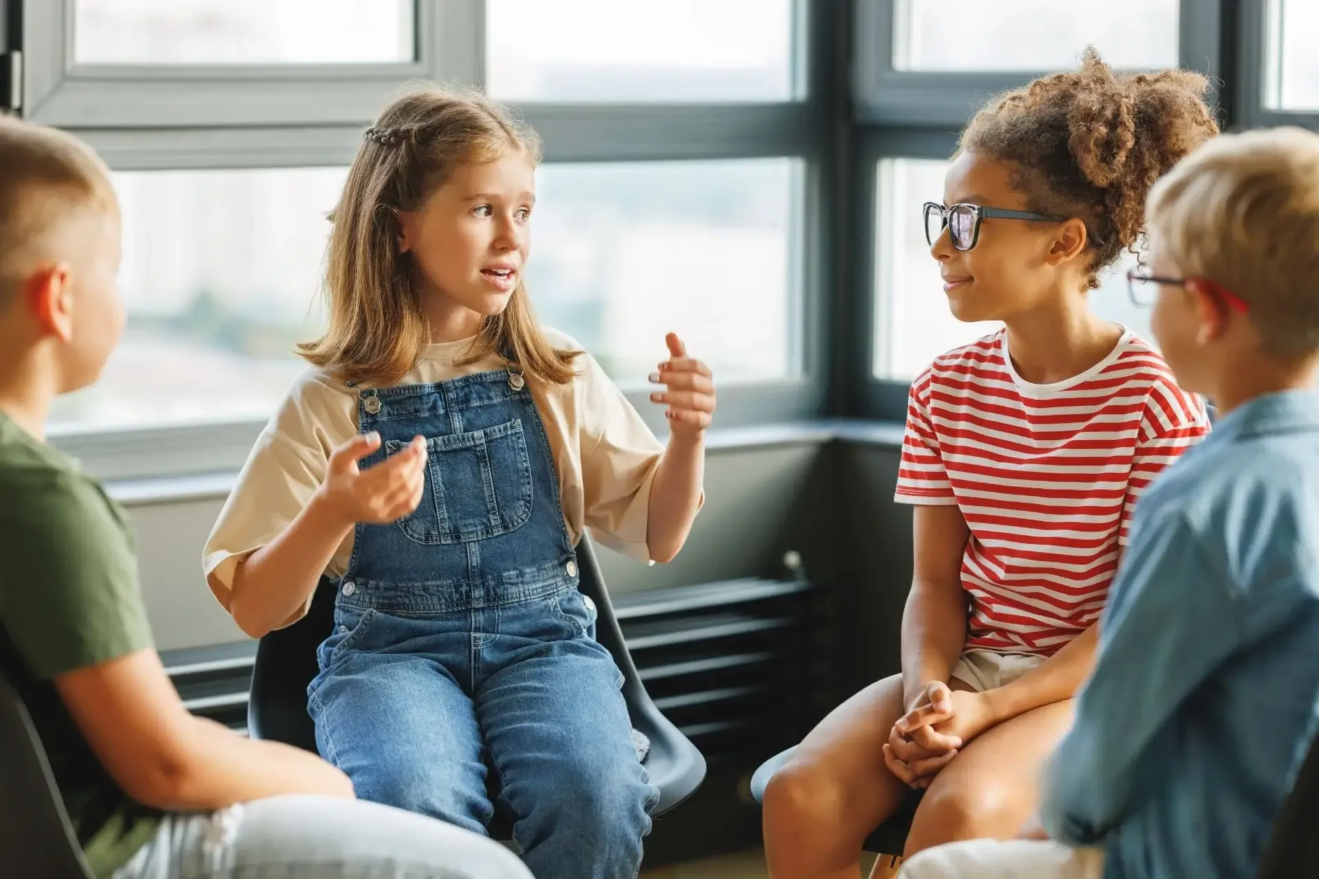 Group of children talking together by a window