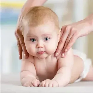 Baby doing tummy time while gentle hands support its back