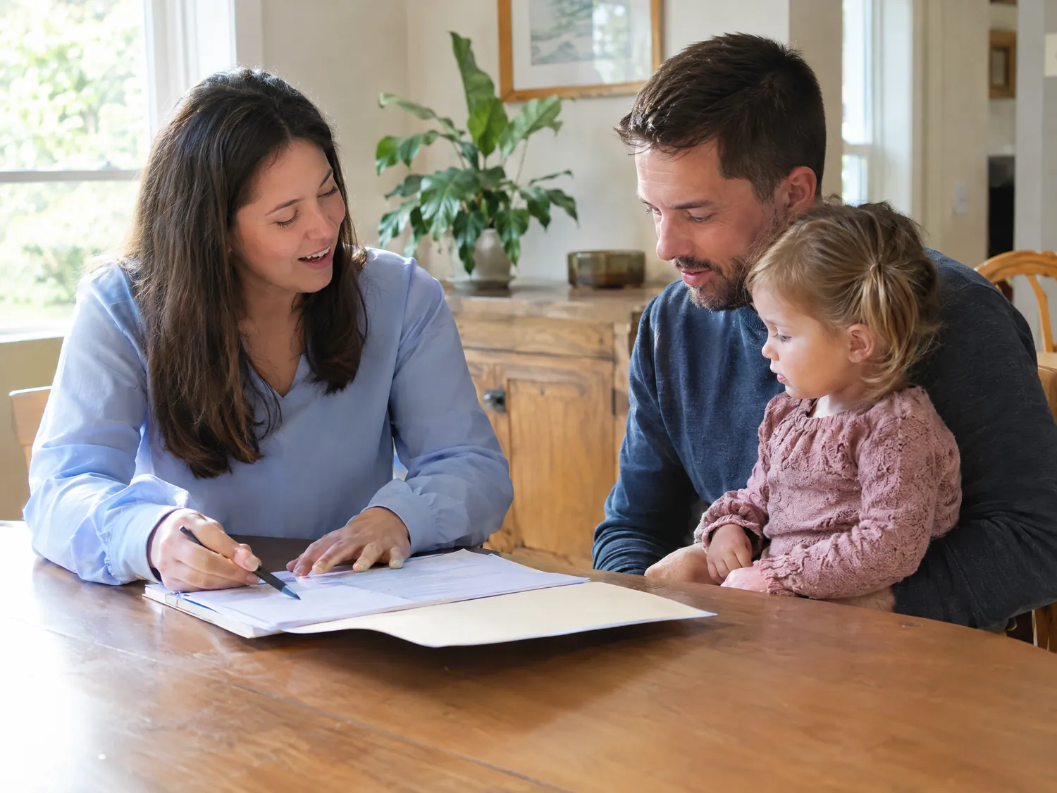 Care coordinator reviewing paperwork with parents and their toddler