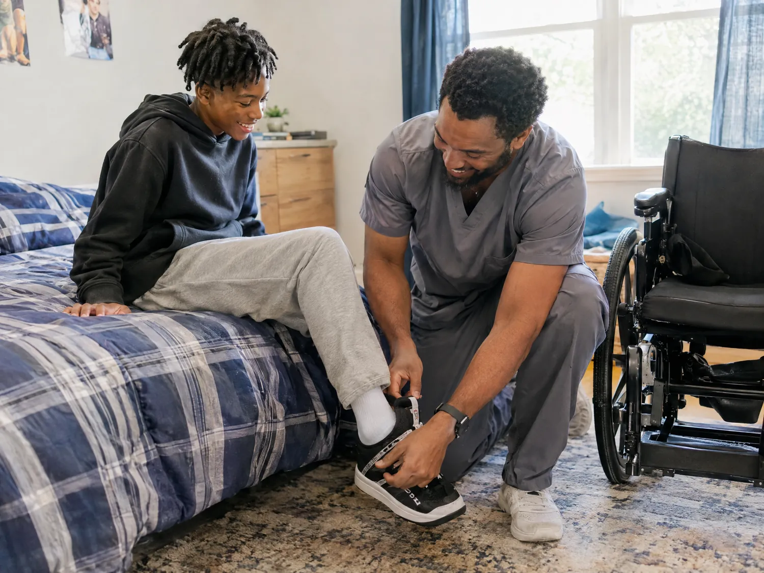 Caregiver helping a teen put on his sneaker beside his wheelchair