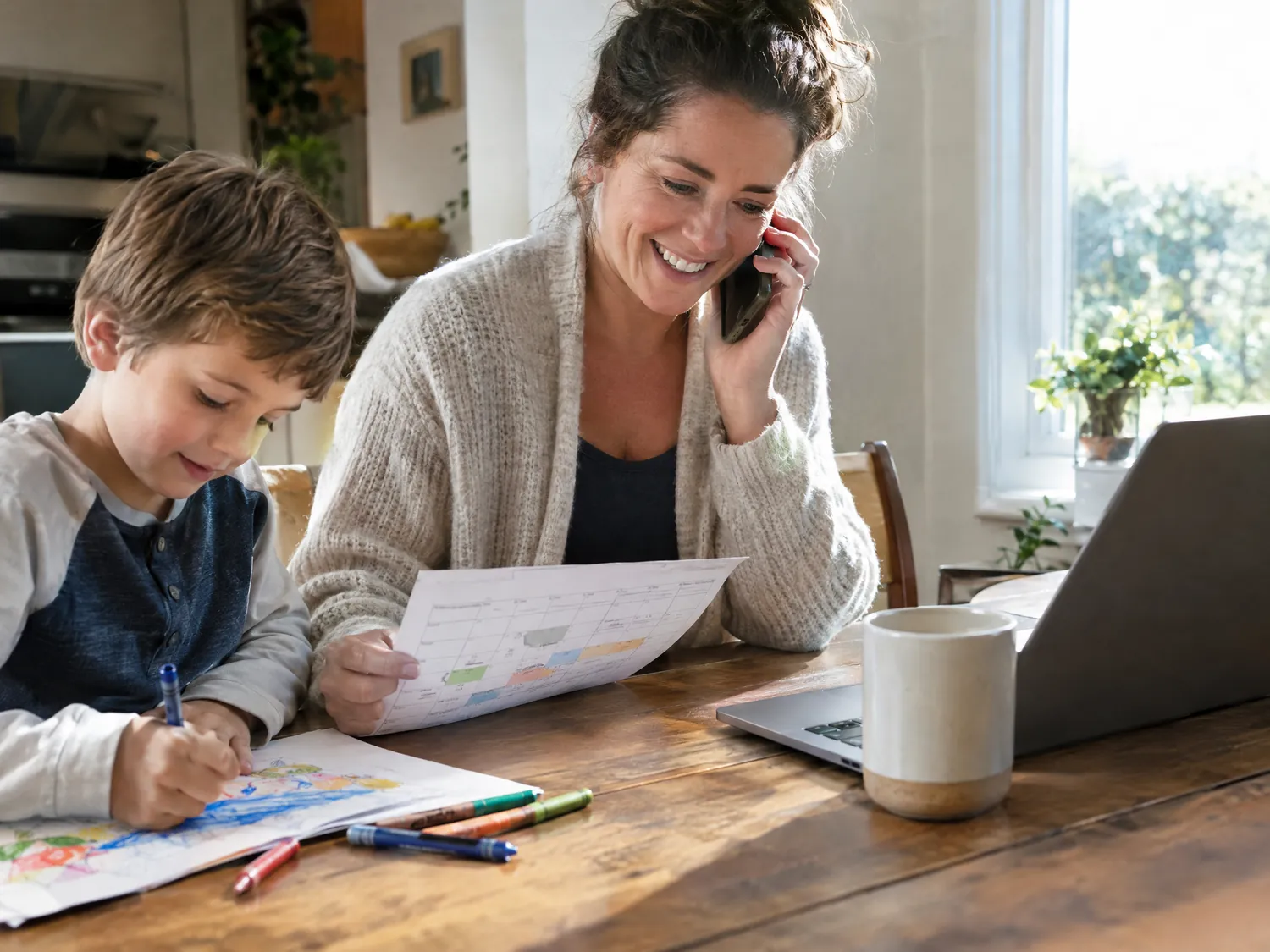 Mother smiling on the phone while reviewing her child’s care schedule